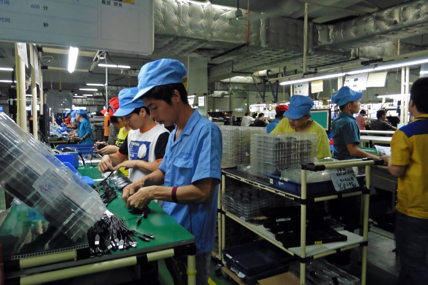 Workers assemble electronics by hand at a factory in China.